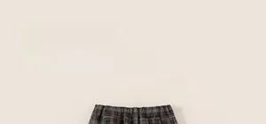 Détail du pantalon écossais gris pour enfant montrant le tissu d'hiver épais et la taille