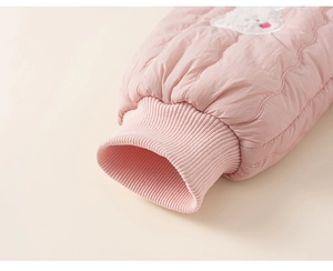 Détail du pantalon rose matelassé avec poignets côtelés et un joli écusson en peluche