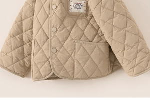 Detail of khaki quilted kids jacket featuring diamond stitching and snap button closure