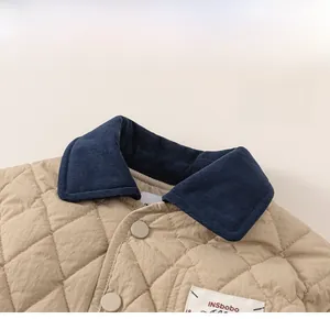 Detail of children's quilted jacket with contrast navy corduroy collar and buttons