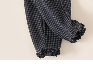 Gros plan des poignets élastiques à volants sur un pantalon à carreaux chaud pour enfant