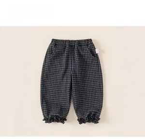 Détail du pantalon à carreaux pour fille avec taille élastique et ourlet à volants