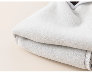 Gros plan sur la texture du tissu polaire gris doux avec couture overlock professionnelle