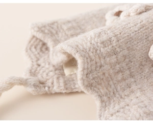 Close-up of oatmeal knit winter hat featuring thickened wool texture and floral detail