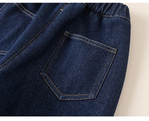 Detail of dark blue denim pants showing yellow double stitching and elastic waistband
