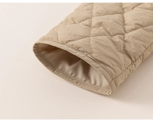 Close-up of diamond-quilted beige kids jacket cuff showing textured fabric and stitching