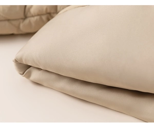 Detailed macro view of the premium quilted fabric and texture on the beige kids winter jacket