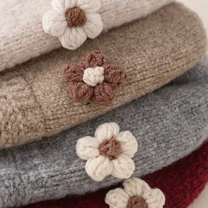 Winter knit baby hats with handmade floral accents in white, brown, grey, and burgundy