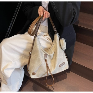 Detailed shot of beige canvas tote bag with brown leather trim and mini coin purse
