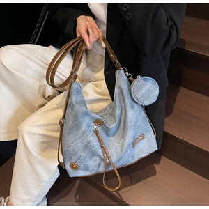 Detail of vintage denim tote bag with leather trim and mini circular pouch attachment