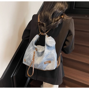 Close-up of light blue vintage canvas tote bag with brown leather straps and mini pouch