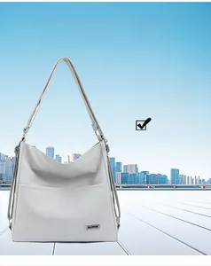 Close-up of a light grey tote bag with two front pockets and an adjustable shoulder strap