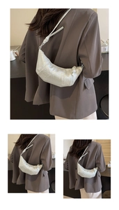 Vue détaillée du sac croissant argenté avec nœud d'épaule et texture plissée élégante