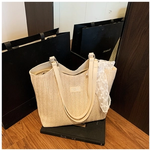Detailed close-up of beige woven tote bag texture with elegant cream PU leather straps