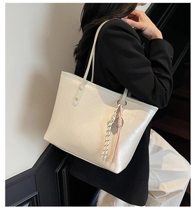 Detail of cream white tote bag with lychee grain texture and elegant metal rivet accents