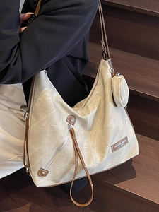 Retro canvas tote bag with brown leather trim and side pouch on wooden stairs