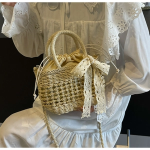 Détail d'un sac seau en paille avec nœud en dentelle délicat et doublure à cordon