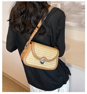 Détail du sac en paille tissée et cuir marron avec une boucle ronde en métal argenté