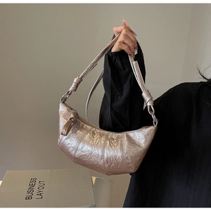 Détail du sac croissant métallisé champagne avec poignée nouée et plis vintage