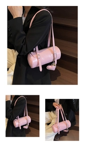 Detailed view of pink barrel bag featuring glossy oil wax leather and heart charm