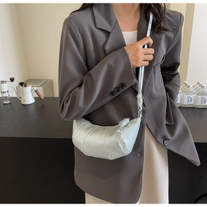 Détail du sac croissant argenté avec texture plissée métallique et fine bandoulière
