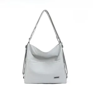 Front view of light gray waterproof nylon tote bag with dual front pockets and metal logo