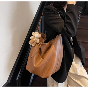 Brown faux leather tote bag detail with drawstring closure and cute teddy bear charm