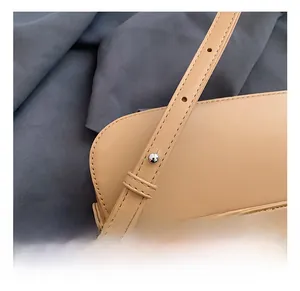 Détail de la bandoulière réglable en cuir avec boucle métallique sur sac en paille