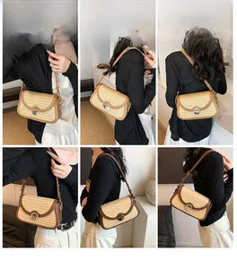 Détail montrant la texture tressée et la bandoulière en cuir d'un sac à main en paille