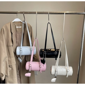 Detail view of colorful glossy cylinder bags with heart charms hanging on a rack