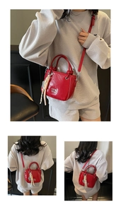 Detailansicht einer leuchtend roten PU-Lederbeuteltasche mit Logo und Quastenanhänger