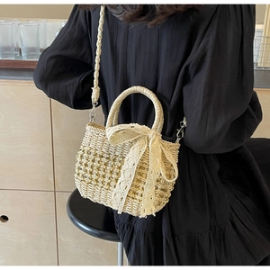 Détail du sac en paille tissé main avec nœud en dentelle et poignée tressée