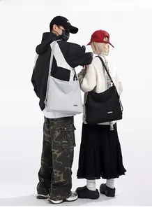Close-up of minimalist large-capacity tote bags in grey and black shown on models