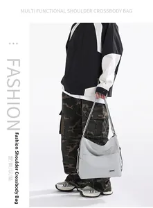 Detail view of light grey tote bag with adjustable strap and metal brand plate