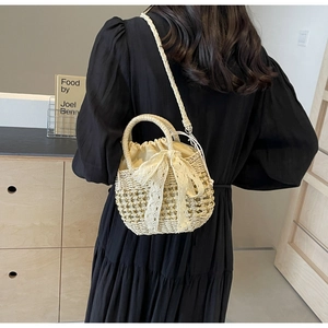 Détail d'un sac en paille avec nœud en dentelle blanche et doublure intérieure