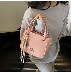 Rosa PU Leder Eimertasche mit Metallic Logo und gestreiftem Anhänger am Modell