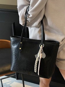 Minimalist black tote bag in embossed leather with a unique tennis racket charm for women