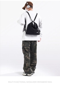 Detail view of durable black nylon tote bag worn by model in street fashion style