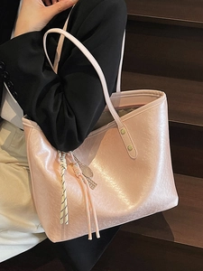 Minimalist light pink tote bag with glossy wrinkled texture on wooden stairs