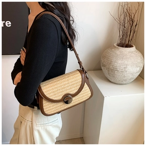 Détail du sac à bandoulière en paille avec garniture en cuir et boucle ronde en métal