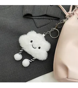 Close-up of a white plush cloud charm with embroidery on a pink handbag strap