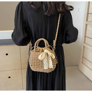 Détail du sac en paille tissé main avec nœud en dentelle blanche et doublure en tissu