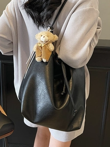 Large black PU leather tote bag with drawstring closure and brown plush bear charm