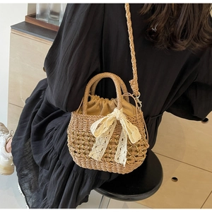 Détail d'un sac en paille français avec nœud en dentelle et chaîne dorée