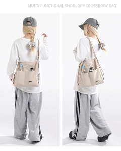 Detail showing multi-pocket nylon tote bag with side pockets for bottle and umbrella