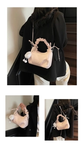 Detail view of pink pleated hobo bag with metal chain strap and white plush charm