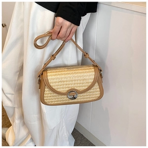Détail d'un sac en paille tressée avec bordure en cuir marron et boucle en métal