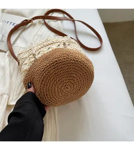 Close-up of bohemian crochet bucket bag with bicolor woven texture and leather strap