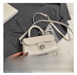 Detail view of cream PU crossbody bag with pearl lace charm and silver twist lock