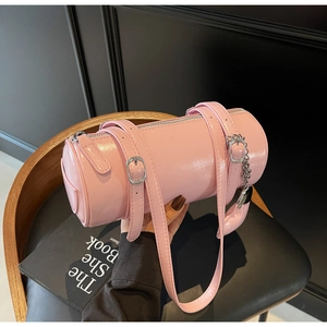 Detail of pink cylindrical barrel bag in glossy patent leather with silver hardware finish